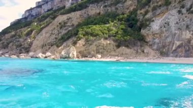 Mavi denizde ve İtalya 'nın Sardunya' nın doğu kıyısındaki Orosei körfezinde kayalık sahillerde geziniyorum. 20 Mayıs 2019