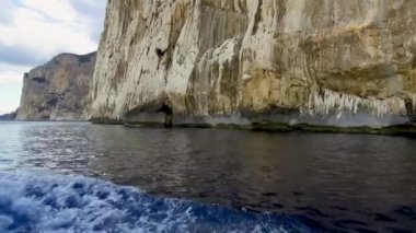 Mavi denizde ve İtalya 'nın Sardunya' nın doğu kıyısındaki Orosei körfezinde kayalık sahillerde geziniyorum. 20 Mayıs 2019