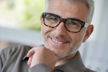 Orta yaşlı adam gözlük ile gülümseyen portresi