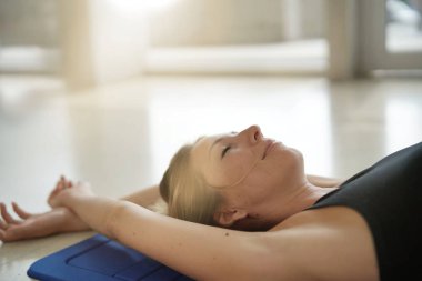 Kadın fitness şilte üzerinde rahatlatıcı spor salonunda