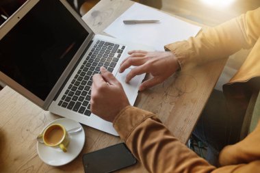 Laptop kahve dükkanında çalışan erkeğin üst görünümü