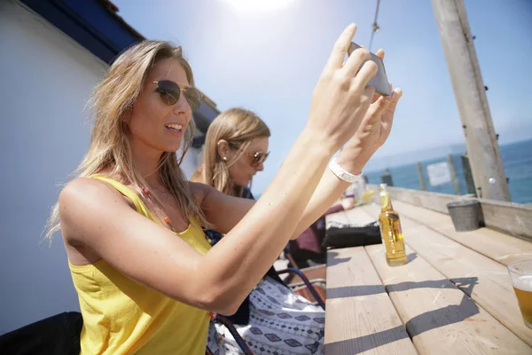 Flickorna Sitter Beach Restaurant Ansluten Med Smartphone — Stockfoto