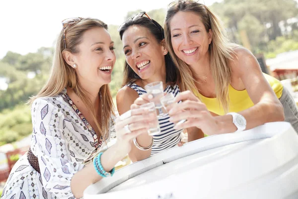 Girls at outdoor party cheering with drinks