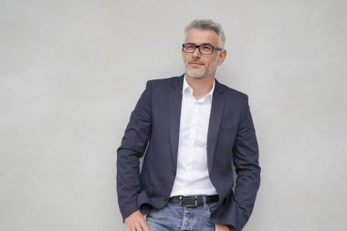 İş adamı izole beton duvara yaslanmış