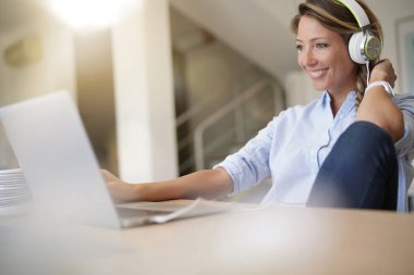 Kadına evde film izlerken laptop, kulaklık