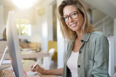 Çalışma alanı ortak masaüstü bilgisayarda çalışan güzel kadın