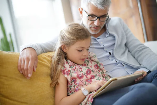 Baba ve kız kanepede oturan tablet ile bağlı