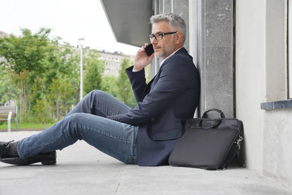 Geschäftsmann Sitzt Auf Bürgersteig Und Telefoniert — Stockfoto