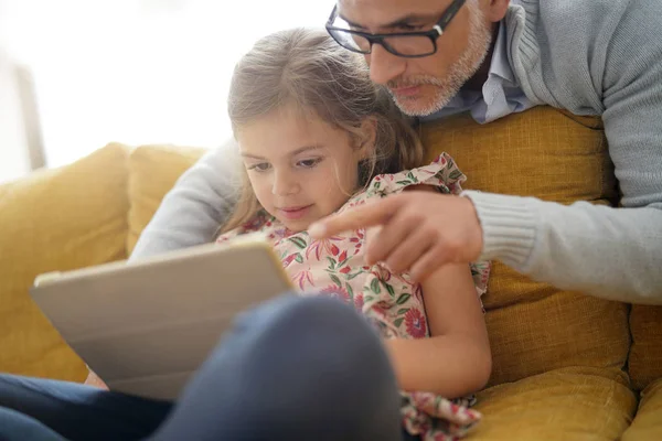 父と娘がソファに座って タブレットと接続 — ストック写真