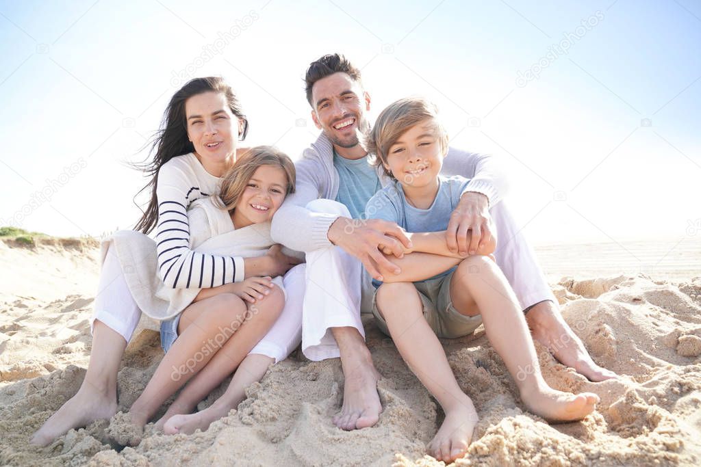 Family sitting on the beach in late afternoon