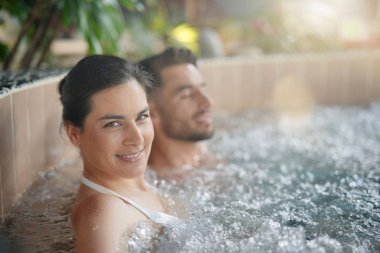 Couple relaxing in spa resort hot pool clipart