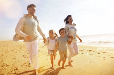 Kumsalda günbatımında çalışan aile