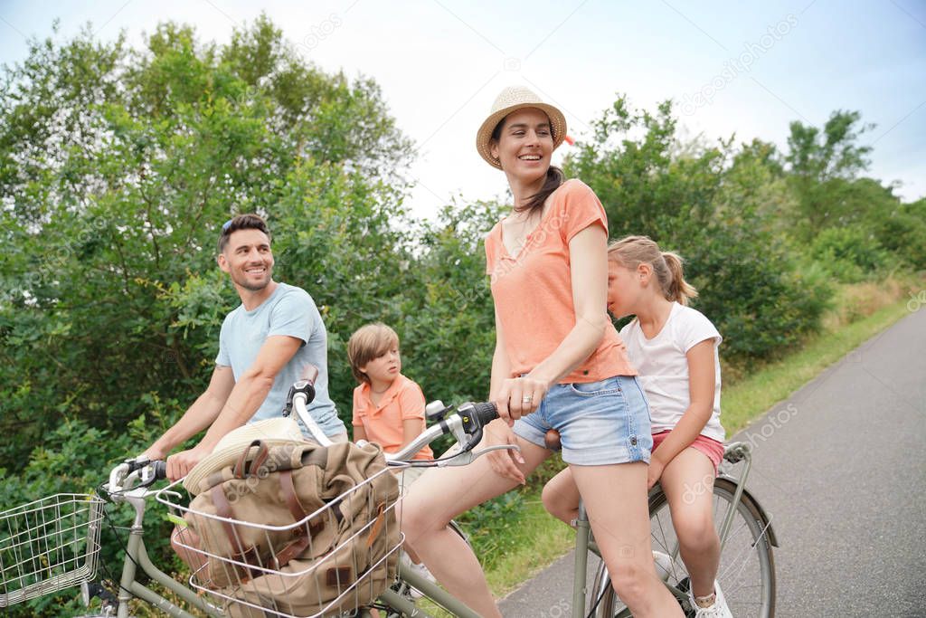 Kids with parents riding bikes in countryside