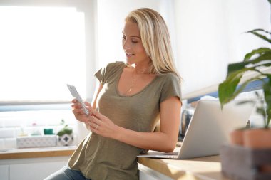 Çekici sarışın kadın evde smartphone kullanarak