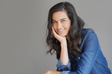 İzole gri arka plan üzerinde duran esmer kadın