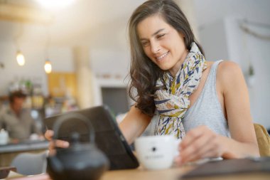 Dijital tablet kullanarak kafede esmer kadın