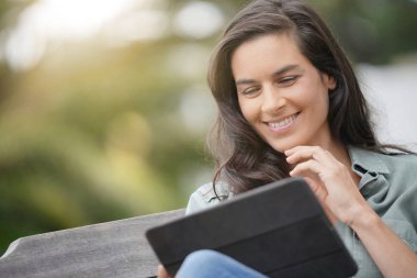Esmer kadın dışında rahatlatıcı tablet ile bağlı
