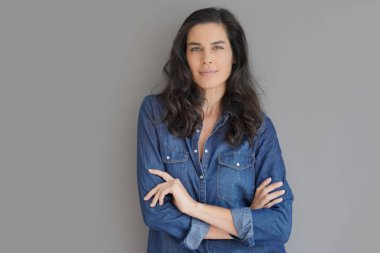 İzole gri arka plan üzerinde duran esmer kadın