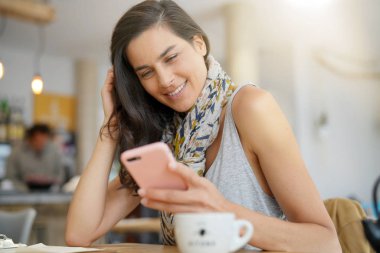 Kafede smartphone kullanarak esmer kadın