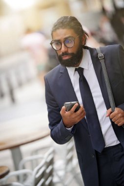 Bir çözüm için akıllı telefon elinde yürüyüş işadamı