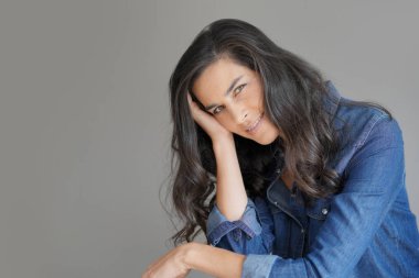 İzole gri arka plan üzerinde duran esmer kadın