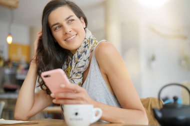 Kafede smartphone kullanarak esmer kadın