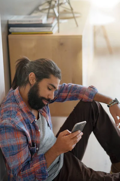 Hipster guy at home connected with smartphone