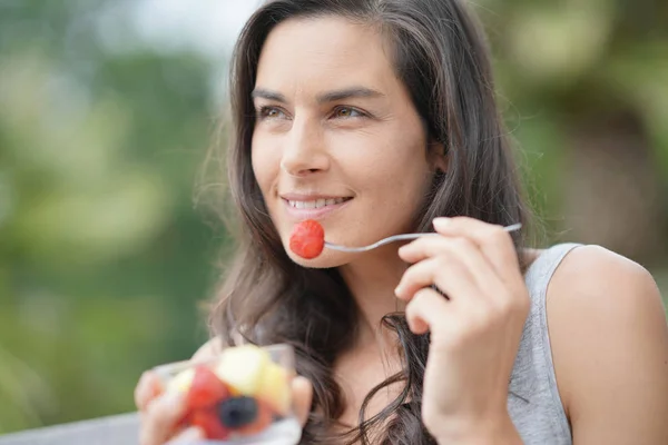 新鮮な果物を食べるブルネットの少女 — ストック写真