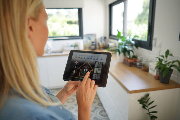 Woman at home using smart screen, automation domestic system