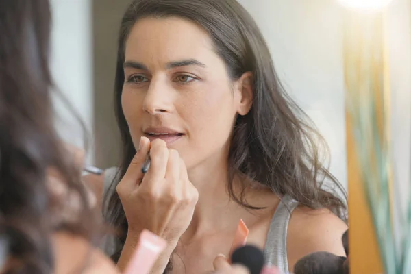 Μελαχρινή Γυναίκα Μπροστά Από Καθρέφτη Εφαρμογή Lipstik — Φωτογραφία Αρχείου