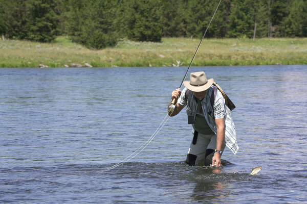 Мужчина-мухомор ловит рыбу в реке
 