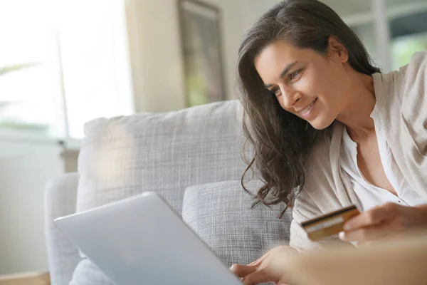 ブルネットの女性のノート パソコンと接続してオンライン ショッピング — ストック写真