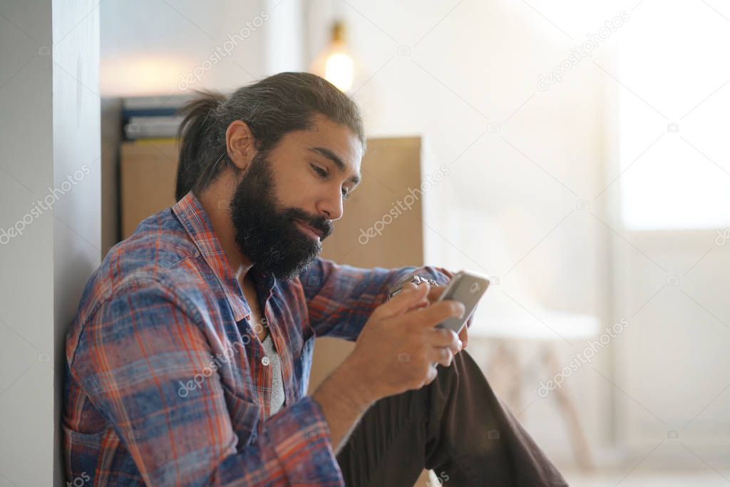 Hipster guy at home connected with smartphone