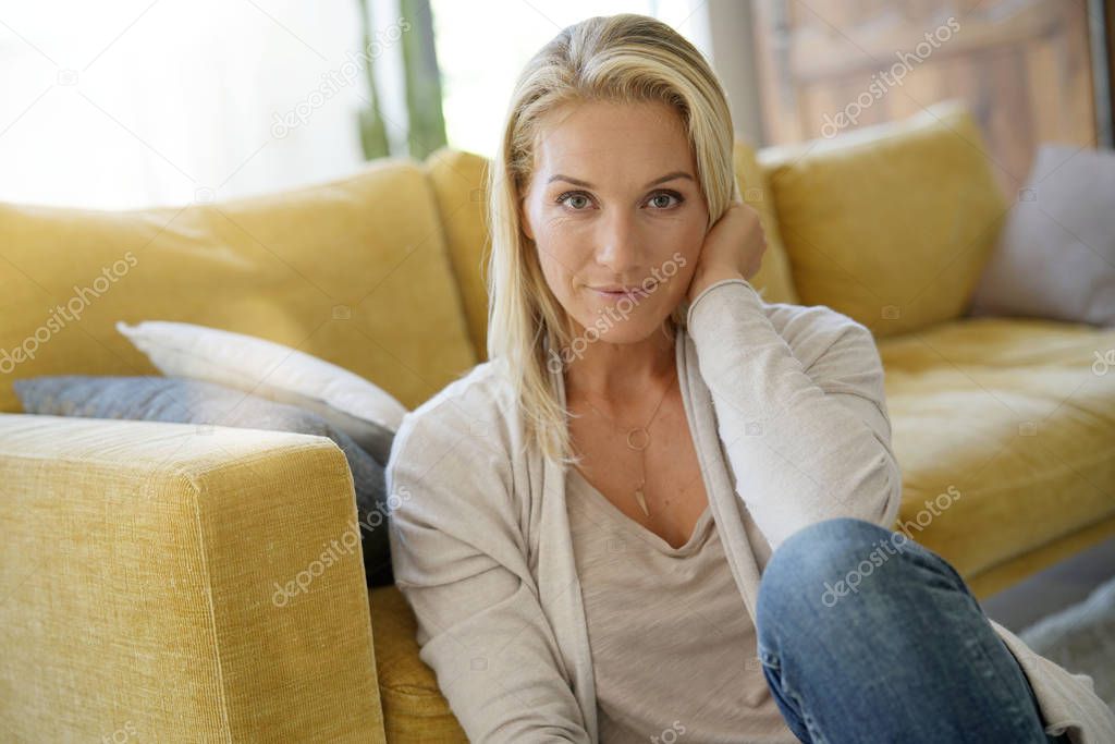 Portrait of attractive blond woman relaxing in sofa