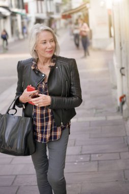  Deri ceket giyiyor şehirde modern üst düzey kadın                              