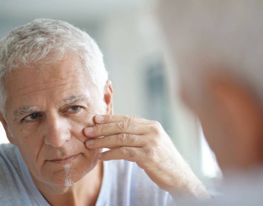 Kozmetik kullanarak ayna önünde olgun adam