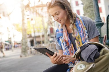 Açık havada tablet vasıl arayan genç kadın                          