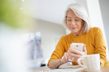 Cep telefonu evde üzerinde modern üst düzey kadın                               