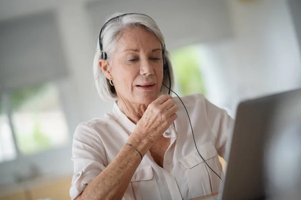 Mujer Mayor Que Trabaja Computadora Con Auriculares — Foto de Stock