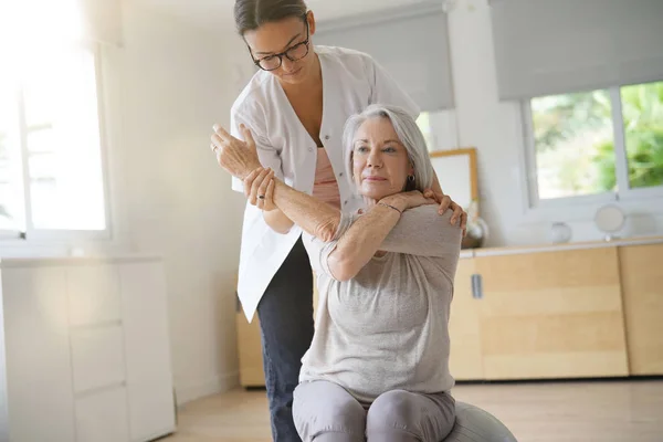 Senior Kobieta Ćwiczenia Jej Fizjoterapeuty Swiss Ball — Zdjęcie stockowe