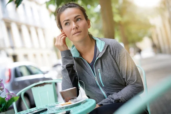 彼女のイヤフォンを調整するカフェで女性 — ストック写真