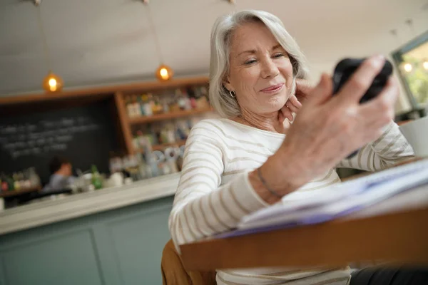 Старша Жінка Дивиться Мобільний Телефон Ресторані — стокове фото