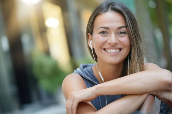 Relaxed and happy woman in an urban setting smiling at the camera