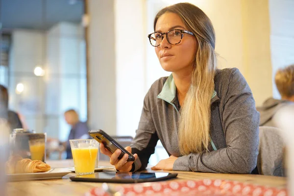 Egy Fiatal Egy Kávézóban Pensively Néz Miközben Mobiltelefon Tartó — Stock Fotó