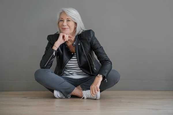 Moderne Senior Vrouw Zitten Binnenshuis Met Lederen Jas — Stockfoto