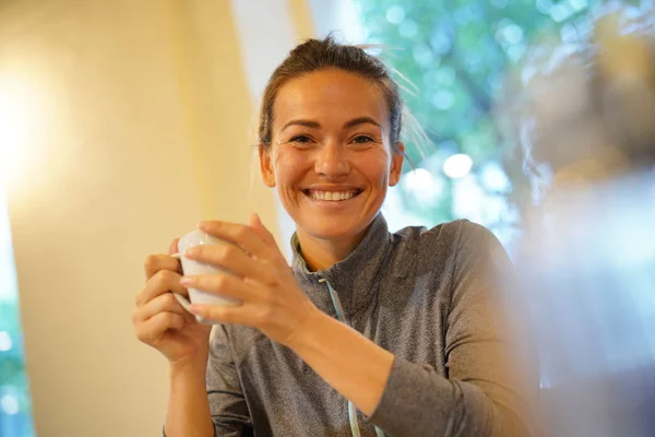 Een Gelukkige Vrouw Met Een Kopje Koffie Binnenshuis — Stockfoto