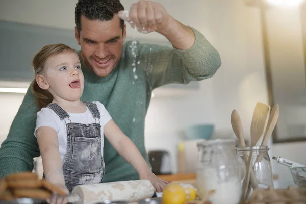 Father and daughter baking at home