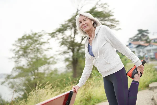 Senior Kvinna Stretching Utomhus Innan Kör — Stockfoto