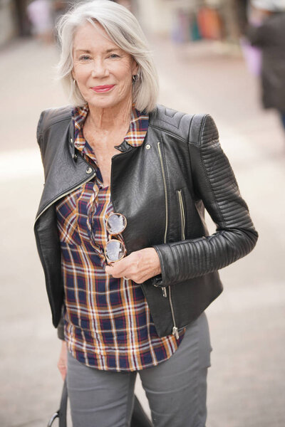  Modern senior woman in town wearing leather jacket                              