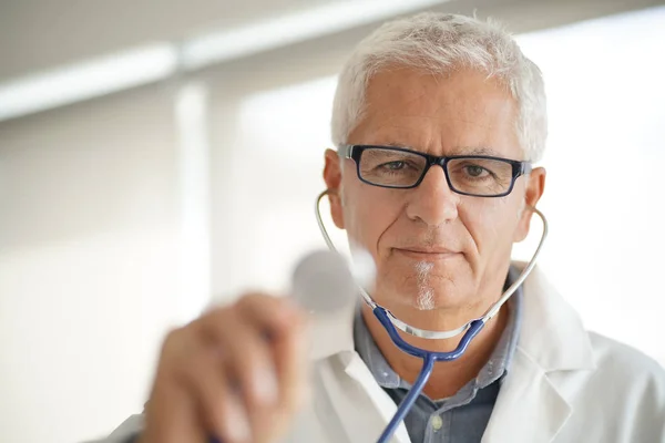 Starszym Lekarzem Wskazując Stethocope Aparat Fotograficzny — Zdjęcie stockowe